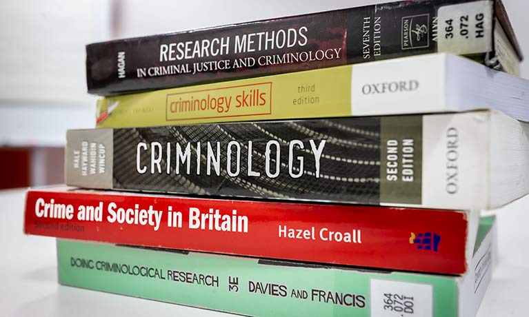 A stack of criminology textbooks.