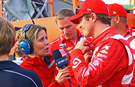Female reporter interviewing a male race driver