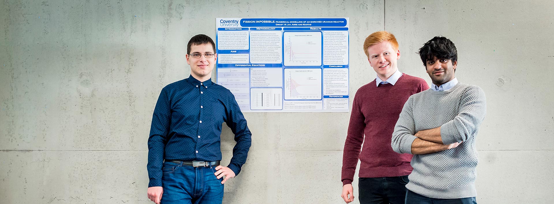 Three students standing in front of a poster.