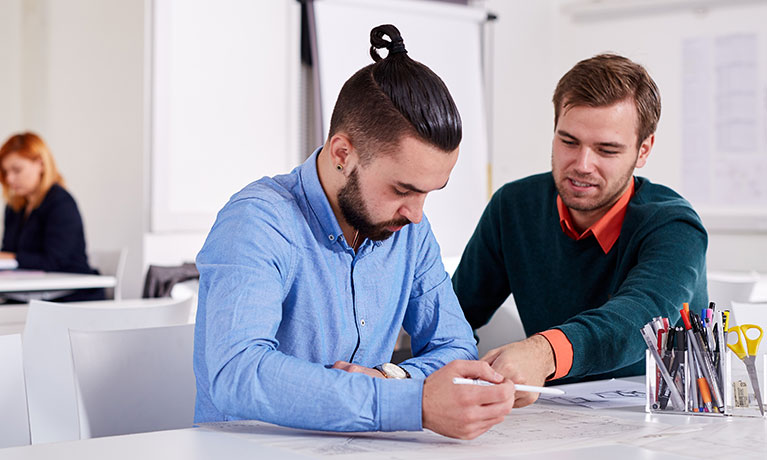 Tutor helping student in a seminar room
