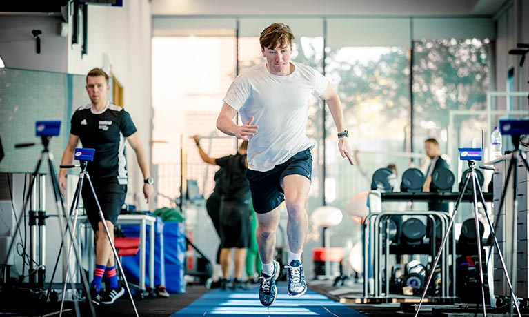 Student running in a sports facility.