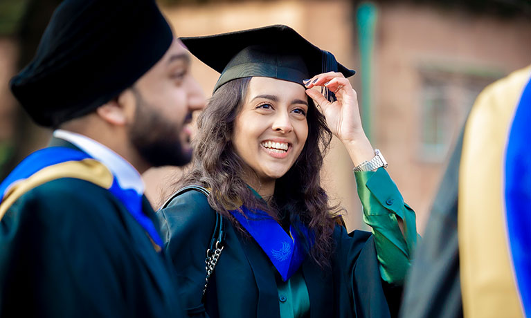 Students smiling in their graduation gowns and caps