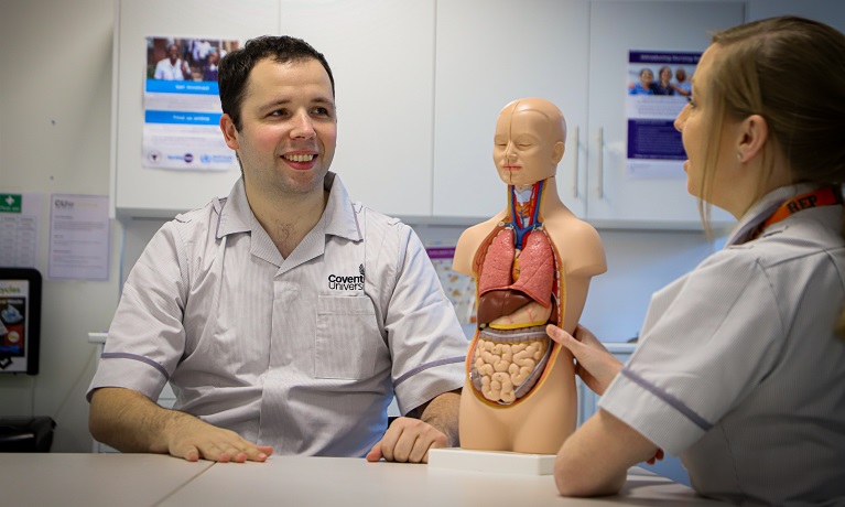 Two nursing students working on a manekin