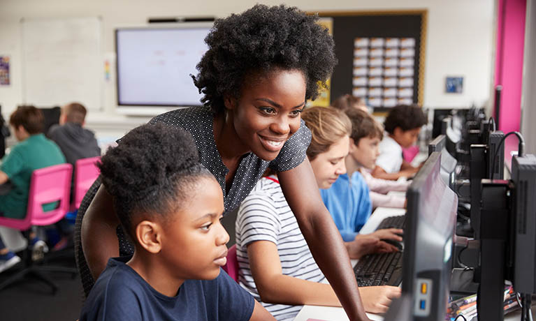 A teacher helping a student in a classroom