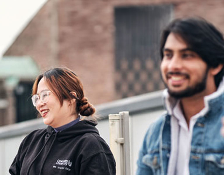 Students smiling together outside the Coventry Cathedral